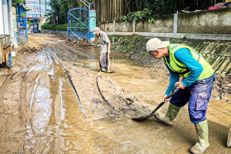 Sejumlah warga membersihkan lumpur sisa banjir di Perumahan Graha Indah,  Kecamatan Cicendo, Kota Bandung, Jawa Barat, Kamis (3/7/2025).