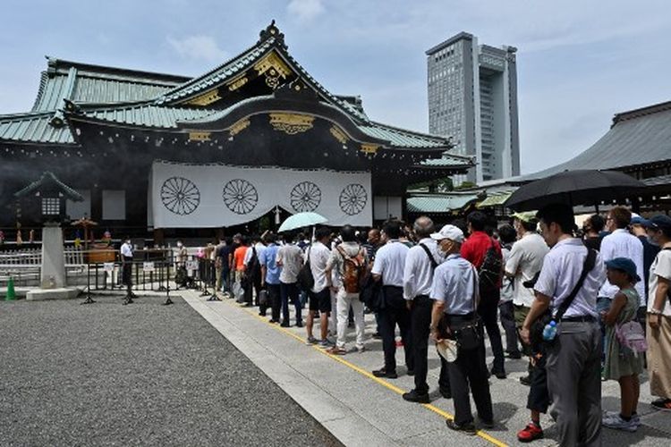 Orang-orang mengantre untuk memberi penghormatan selama kunjungan ke Kuil Yasukuni di Tokyo pada 15 Agustus 2022, untuk menandai peringatan 77 tahun penyerahan Jepang dalam Perang Dunia II pada 1945. Dua menteri Jepang memberi penghormatan pada 15 Agustus di kuil perang yang kontroversial dilihat oleh negara-negara tetangga sebagai simbol militerisme masa lalu, sebagai bangsa memperingati berakhirnya Perang Dunia II. 