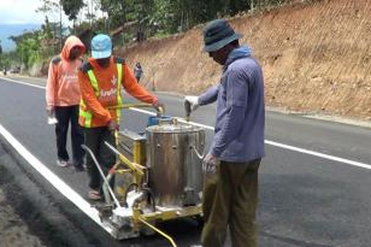 Sejumlah pekerja melakukan finishing yaitu membuat marka jalan di Tanjakan Ciregol, Tonjong, Brebes, Jawa Tengah sebelum dilintasi kendaraan.
