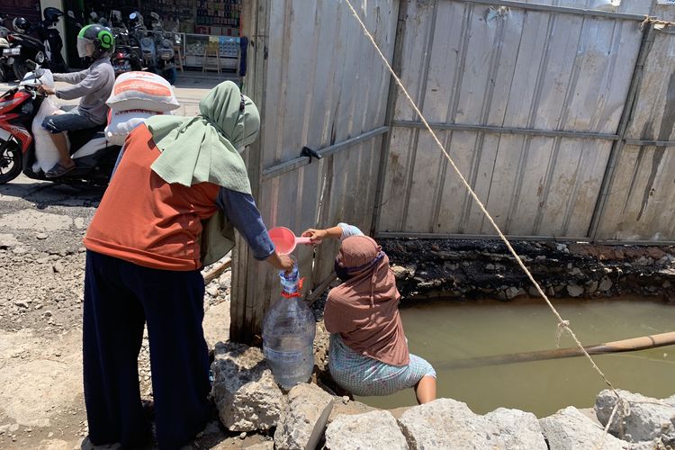 Warga Bekasi berbondong-bondong mengambil air dari kubangan pipa PDAM yang bocor di Jalan Raya Tarumajaya, Desa Setiamulia, Kecamatan Tarumajaya, Kabupaten Bekasi, Rabu (27/9/2023). Warga berdatangan membawa ember dan galon demi mendapatkan pasokan air untuk kebutuhan rumah tangga.