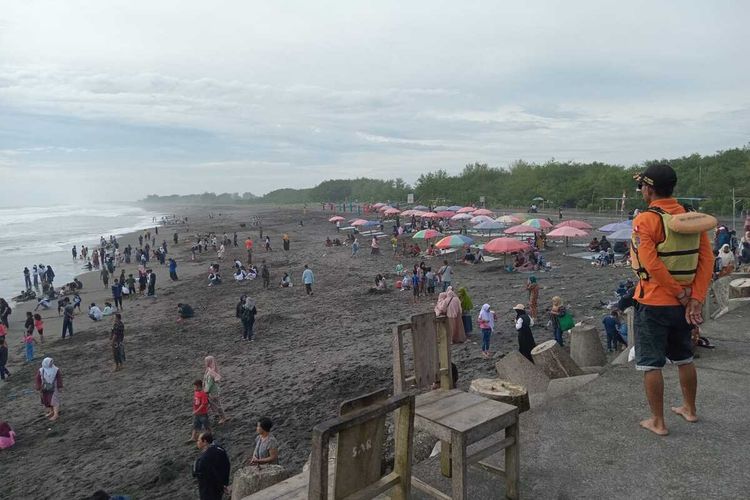 Relawan Satlinmas Rescue Istimewa SRI Wilayah V Kulon Progo memantau aktivitas wisatawan di pantai wisata Glagah, Kapanewon Temon, Kabupaten Kulon Progo, Daerah Istimewa Yogyakarta.