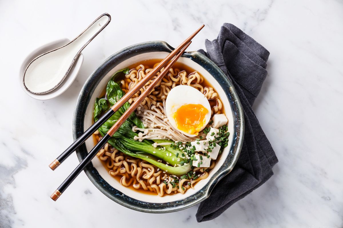 Ilustrasi ramen dengan topping jamur enoki, telur, dan pok choy. 