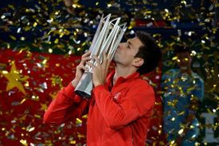 Petenis Serbia, Novak Djokovic mencium trofi juara Shanghai Open, yang didapat setelah mengalahkan Juan Martin del Potro dari Argentina, pada laga final yang berlangsung di Qizhong Tennis Stadium, Shanghai, Minggu (13/10/2013).  Djokovic menang 6—1, 3-6, 7-6 (3).