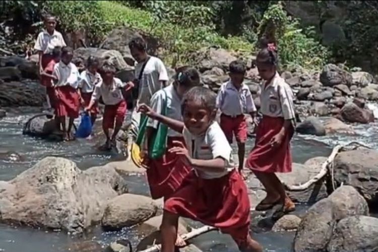 Foto: Siswa sekolah dasar di Dusun Lewomudat, Desa Waipaar, Kecamatan Talibura, Kabupaten Sikka Nusa Tenggara Timur (NTT) menyeberangi sungai menuju sekolah.