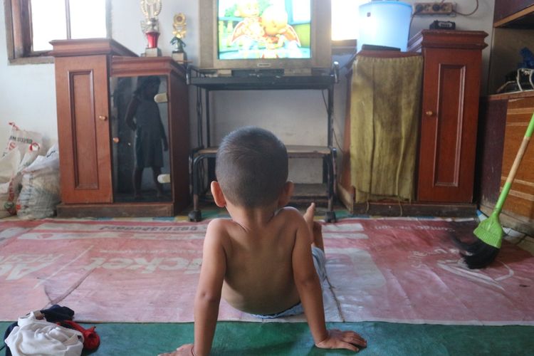 Rangga, salah seorang balita stunting di Belawan Sicanang saat sedang menonton televisi di rumahnya 