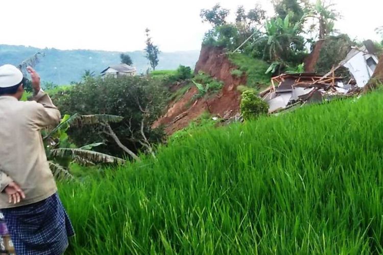 Seorang warga memerhatikan kondisi rumah yang ambruk akibat pergerakan tanah lanjutan di Kampung Sindanglangu, Desa Batulawang, Kecamatan Cipanas, Cianjur, Jawa Barat.
