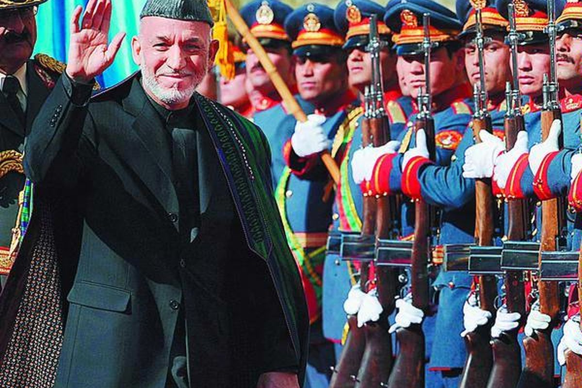 Presiden Afganistan Hamid Karzai (kedua dari kiri) melewati pasukan kehormatan, saat ia tiba untuk diambil sumpahnya sebagai presiden di Istana Kepresidenan di Kabul, Kamis (19/11). Ini adalah masa jabatan kedua Karzai.