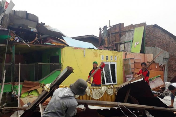 Angin puting beliung dan hujan deras menerbangkan atap rumah dan merobohkan sejumlah bangunan warga di Kota Medan, Rabu (18/7/2018).