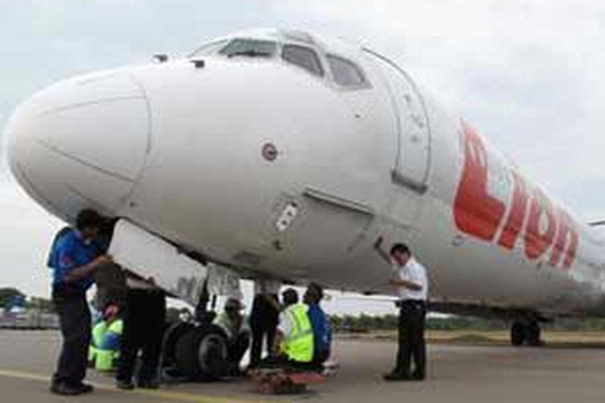 Petugas KNKT dan petugas dari maskapai Lion Air memeriksa pesawat Lion Air  MD 90 Nomor penerbangan JT-972 di Bandara Hang Nadim, Batam, Selasa (24/2). Pesawat ini mendarat darurat di bandara tersebut, Senin (23/2), beruntung tidak seorang penumpang pun cedera.
