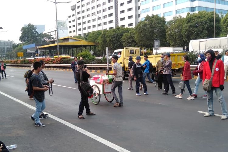 Pedagang es cincau ikut masuk ke jalur tol depan Gedung DPR saat aksi demo berlangsung, Selasa (24/9/2019).