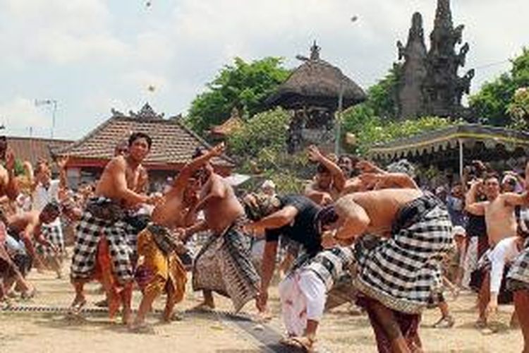 Warga Desa Adat Kapal, Kecamatan Mengwi, Kabupaten Badung, Bali, mengadakan ritual siat tipat bantal atau perang dengan menggunakan ketupat dan penganan bantal di jaba (halaman) Pura Desa dan Pura Puseh Desa Adat Kapal, beberapa waktu lalu. 