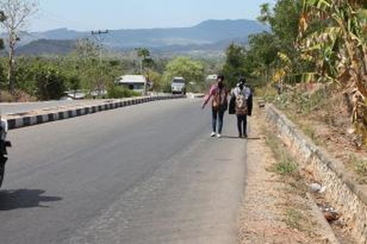 Yanti Neonbeni dan Tini Lafu, dua mahasiswi Fakultas Ekonomi semester 1 Universitas Negeri Timor, Kefamenanu, Kabupaten Timor Tengah Utara (TTU), NTT, berjalan kaki dari kampus mereka kembali ke rumah