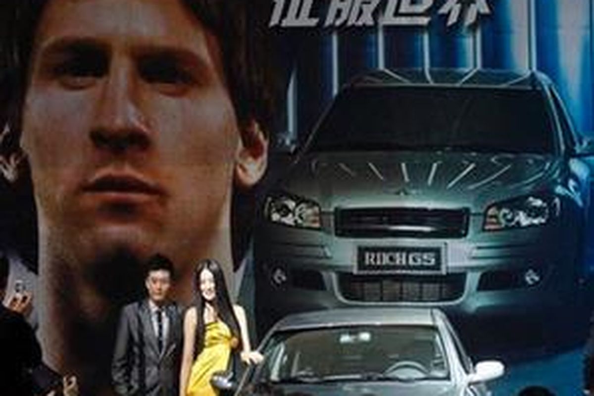 Models pose near a Riich G5 car developed by the Chery Automobile Co. in front of an advertisement featuring Argentine soccer star Lionel Messi at the Beijing Auto China 2010 in Beijing Friday, April 23, 2010. Chinas biggest domestic auto brand signaled its ambition Friday to become a global player by signing Messi as an international ambassador to promote its brands. 