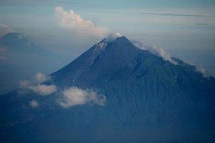 Puncak gunung berapi tipe Strato-volcano Merapi menjulang dengan ketinggian 2.978 meter di kawasan Provinsi DI Yogyakarta dan Jawa Tengah, Minggu (21/4/2013). Meskipun memiliki risiko bencana alam, jutaan warga terus bertahan bermukim di kaki gunung itu antara lain karena kesuburuan tanah vulkaniknya yang memungkinkan mereka hidup dengan bercocok tanam.