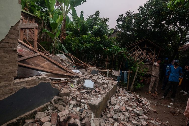 Warga melihat kondisi rumah yang rusak akibat gempa di Kadu Agung Timur, Lebak, Banten, Jumat (14/1/2022). Gempa berkekuatan M 6,6 tersebut mengakibatkan sejumlah rumah rusak. ANTARA FOTO/Muhammad Bagus Khoirunas/rwa.