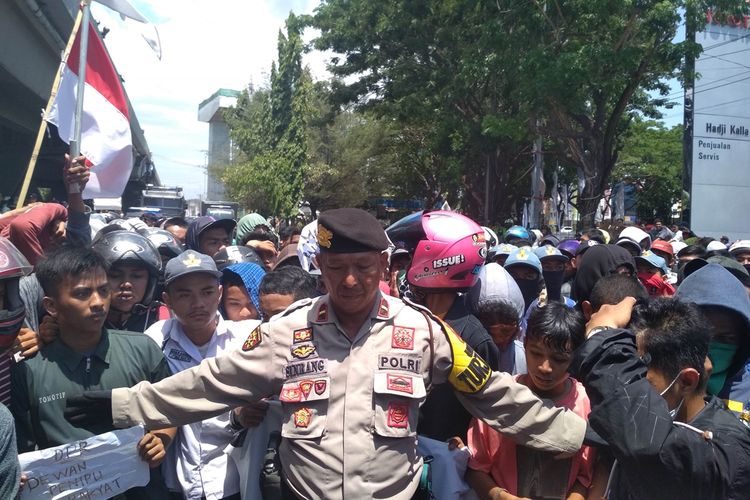 Seorang polisi saat coba menghalangi para pelajar di Makassar yang hendak berunjuk rasa di depan Gedung DPRD Sulawesi Selatan di Jalan Urip Sumoharjo, Kamis (26/9/2019).