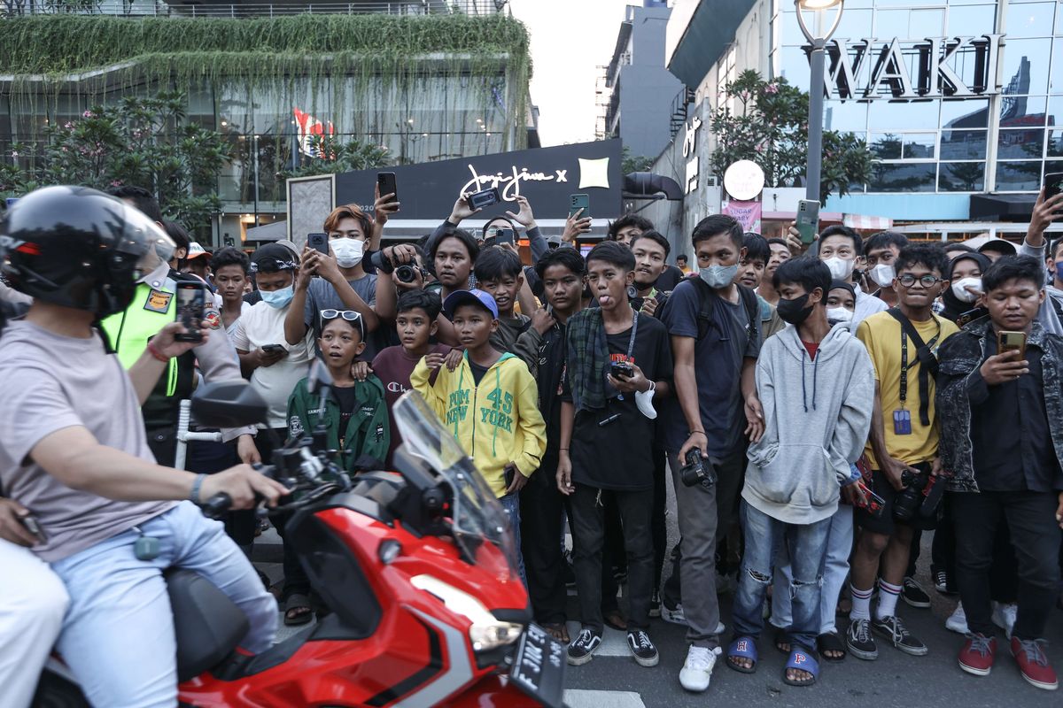 Pengunjung menunggu menyaksikan peragaan busana jalanan di kawasan Dukuh Atas, Jakarta, Rabu (20/7/2022).  Fenomena Citayam Fashion Week di kawasan Dukuh Atas mendadak viral karena gaya busana nyentik yang didominasi anak muda dari Depok, Citayam, dan Bojonggede.