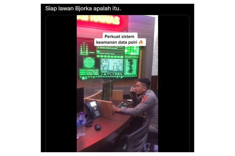 Viral video seoarang anggota polisi berada di antara layar yang dipenuhi dengan data-data komputer berwarna hijau.