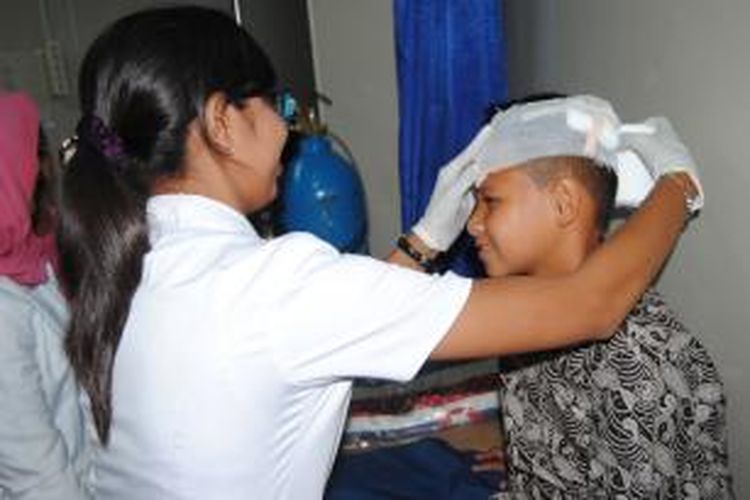 seorag petugas medis di rumah sakit Bakti Rahayu tengah merawat luka dibagian kepalayang diderita Imanio Kristo Waas (10) siswa kelas enam SD di AMbon yang dipukuli gurunya dengan pisau kater, Sabtu (19/9/2015)