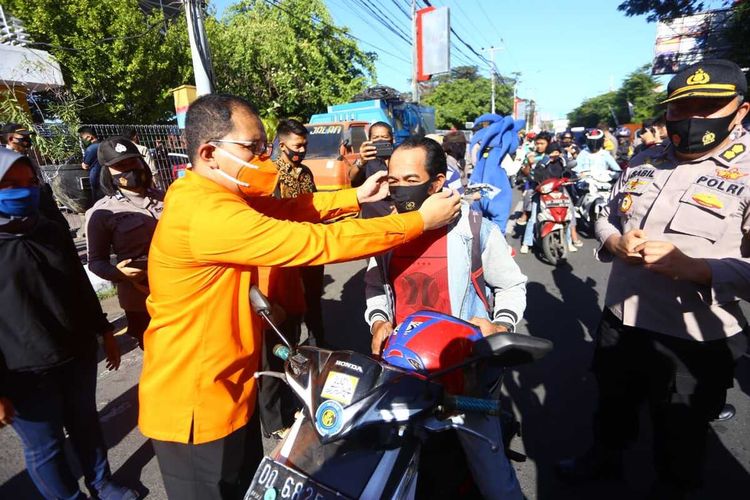 Bakal Pasangan Calon Wali Kota Makassar, Mohammad Ramdhan Pomanto ikut bersama aparat kepolisian membagikan masker kepada pengguna jalan dalam operasi yustisi penegakan disiplin protokol kesehatan, Kamis (10/9/2020).