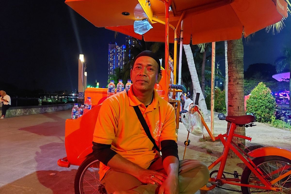 Teguh Wiyono (50) merupakan salah satu pedagang minuman yang berjualan di Taman Impian Jaya Ancol, Jakarta Utara. Foto diambil pada Minggu (26/3/2023).