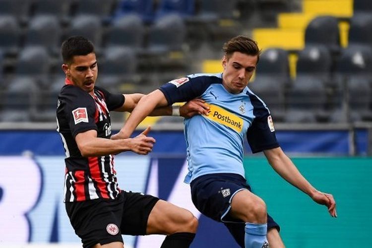 Penyerang Eintracht Frankfurt, Andre Silva, berebut bola dengan pemain Borussia Moenchengladbach, Florian Neuhaus, pada lanjutan pekan ke-26 Bundesliga di Stadion Commerzbank-Arena, Sabtu (16/5/2020).