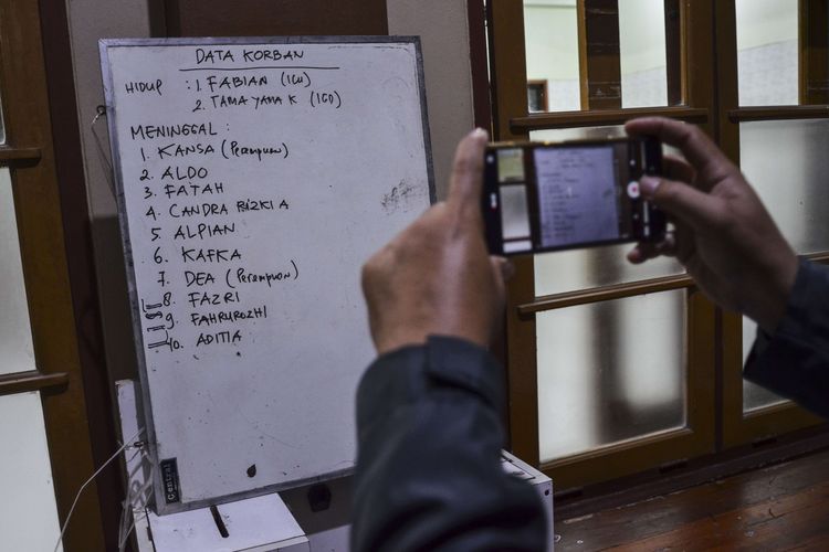 Warga memotret papan tulis berisi data korban tenggelam di RSUD Ciamis, Jawa Barat, Jumat (15/10/2021). Sebanyak 11 siswa MTS Harapan Baru yang mengikuti kegiatan pramuka susur sungai tewas tenggelam dan dua siswa kritis.
