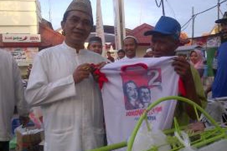 Mantan Bupati Pamekasan, KH. Kholilurrahman, turun jalan bagi-bagi takjil gratis bersama tukang becak untuk memenangkan pasangan Jokowi-JK di Pamekasan, Jumat (4/7/2014). 