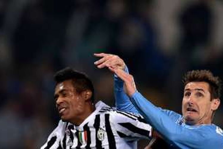 Alex Sandro dan Miroslav Klose berebut bola di udara saat Juventus menjamu Lazio di Juventus Stadium, Jumat (4/12/2015). 