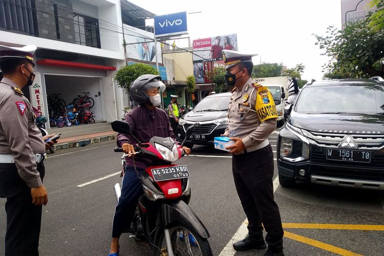 Satlantas Polres Blitar menghentikan pengguna jalan di Jalan Urip Sumoharjo, Kecamatan Wlingi, Kabupaten Blitar, Jumat (26/11/2021) dalam kampanye taat prokes dan vaksin Covid-19.