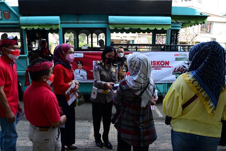 Petugas kepolisian membantu sosialisasi program triple untung plus di Kota Bandung, Selasa (24/8/2021). Program ini diselenggarakan selama Agustus 2021 untuk mendongkrak pembayaran wajib pajak kendaraan.