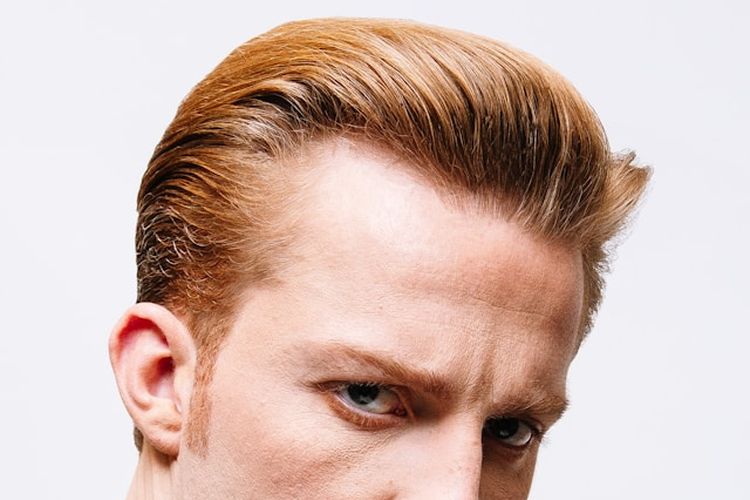 Gaya rambut slicked back pompadour. Panjang di bagian atas dan ditata naik untuk memberikan kesan bervolume.