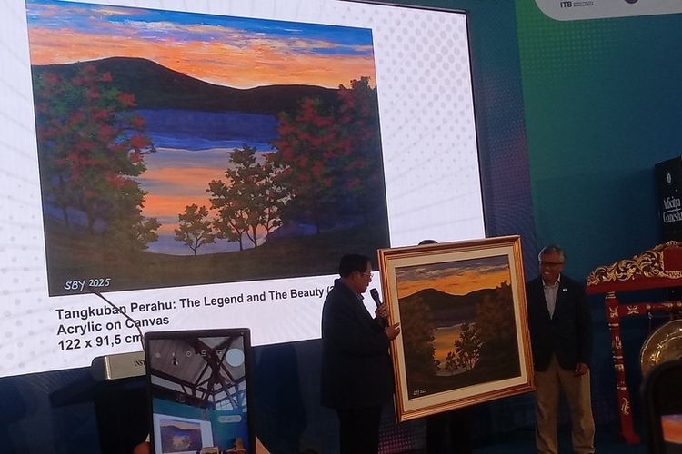 Mantan Presiden Indonesia Susilo Bambang Yudhoyono tengah menyerahkan karya lukisannya bertajuk “Tangkuban Parahu: The Legend and The Beauty” di Acara Adicitra Ganesha, di Aula Barat Kampus ITB, Rabu (8/10/2025).