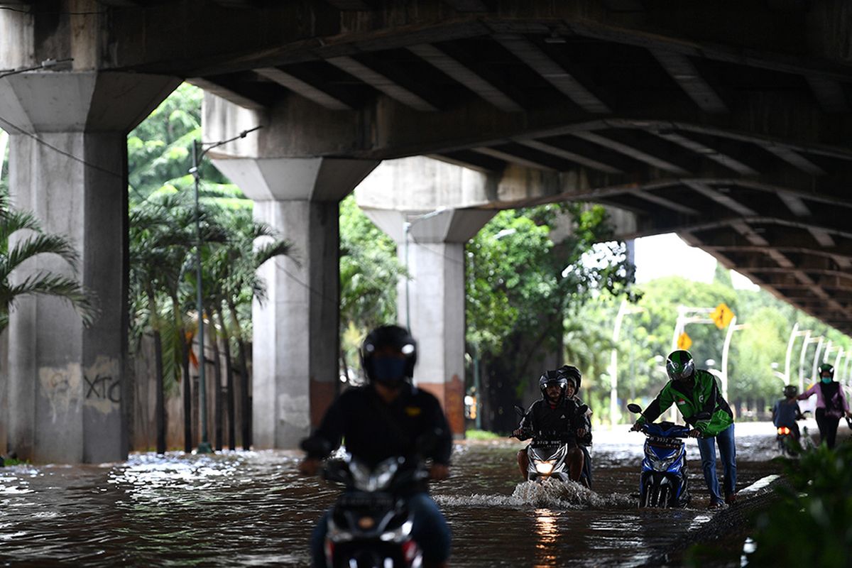 Pengendara sepeda motor mencoba melintasi banjir di Jalan Yos Sudarso, Kelapa Gading, Jakarta Utara, Minggu (23/2/2020). Hujan deras sejak Minggu 23 Februari dini hari membuat sejumlah daerah di Ibu Kota tergenang banjir.