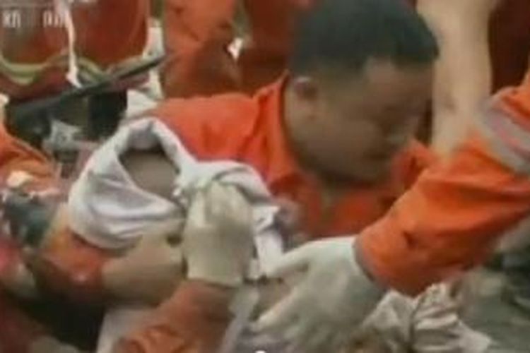 Tim penyelamat di China mengangkat seorang bocah usia 15 bulan yang selamat dari tanah longsor.