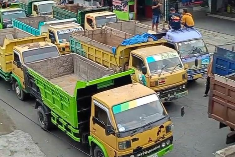 Puluhan truk memenuhi jalan di Desa Penataran, Kecamatan Nglegok, Kabupaten Blitar dalam aksi unjuk rasa penambang pasir menolak kebijakan Pemerintah Kabupaten Blitar mengintensifkan pemungutan pajak tambang, Jumat (4/7/2025).