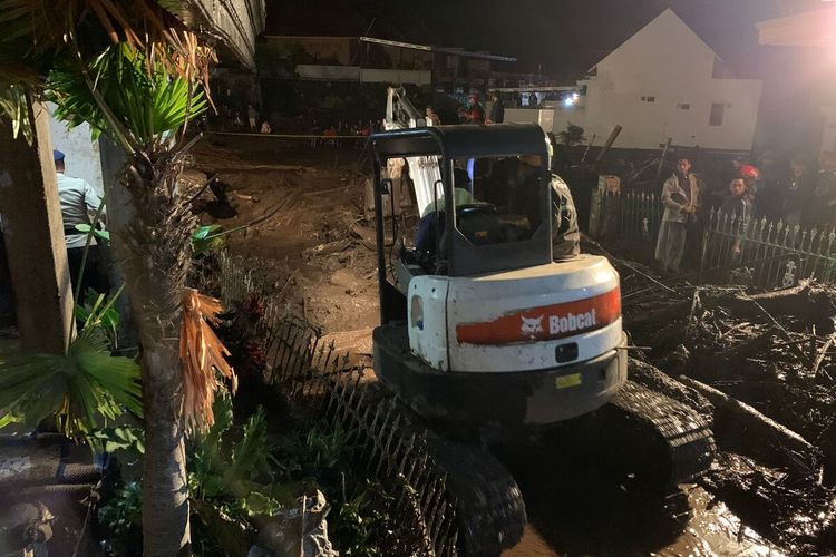 Kendaraan berat diterjunkan untuk membersihkan material banjir di Sambong, Dusun Gintung, Desa Bulukerto, Kecamatan Bumiaji, Kota Batu, Kamis (4/11/2021) malam.
