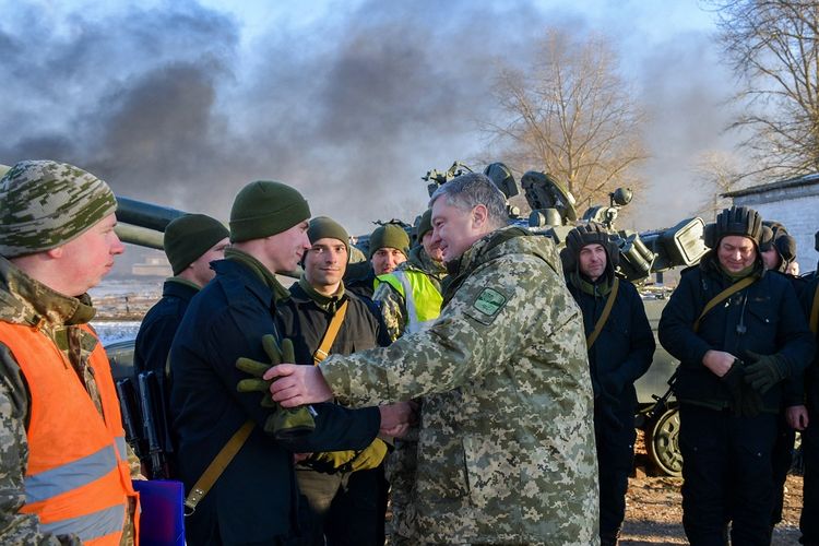 Dalam foto yang dirilis 28 November 2018, Presiden Ukraina Petro Poroshenko (kanan) berbicara dengan kru tank saat latihan di dekat kota Chernihiy, kawasan utara Ukraina.