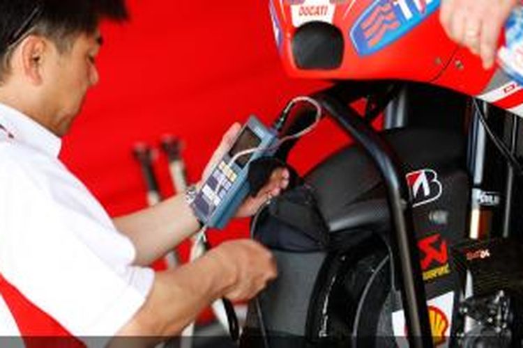 Salah satu kru Ducati sedang melakukan pengecekatn terhadap Desmosdici GP15 pada hari pertama uji coba kedua di Sirkuit Sepang, Malaysia, Senin (23/2/2015).