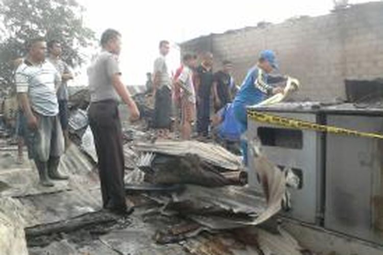 Petugas memasang garis polisi di gardu listrik yang menjadi penyebab kebakaran puluhan rumah di Kelurahan Taman Baloi, Batam, Minggu (14/7/2013) setelah sahur. Tidak ada korban jiwa, namun kerugian material mencapai ratusan juta rupiah. 