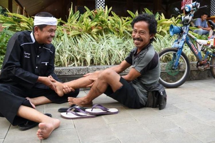 Bupati Purwakarta Dedi Mulyadi memijat kaki seorang warganya