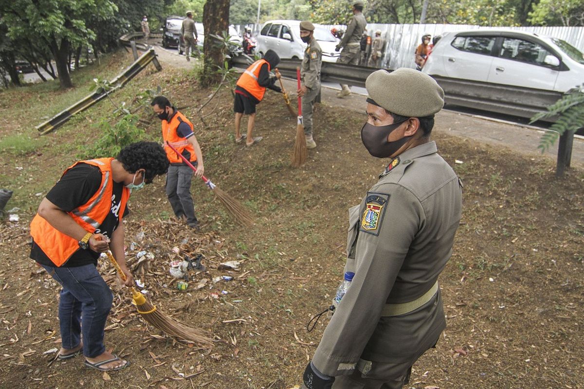 Petugas gabungan memberikan sanksi kerja sosial kepada warga yang tidak menggunakan masker di Simpang UI, Perbatasan Kota Depok - Jakarta, Sabtu (5/9/2020). Operasi masker tersebut dilakukan oleh petugas gabungan Jawa Barat dengan DKI Jakarta sebagai bentuk pengawasan dan penindakan bagi pelanggar protokol kesehatan COVID-19. ANTARA FOTO/Aspprilla Dwi Adha/pras.