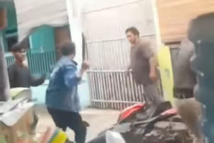 Tangkapan layar dari video unggahan akun @bekasi_24_jam yang memperlihatkan dua orang pria menyerang warga menggunakaan badik di Gang Asem, Perwira, Bekasi Utara, Minggu (11/12/2022).