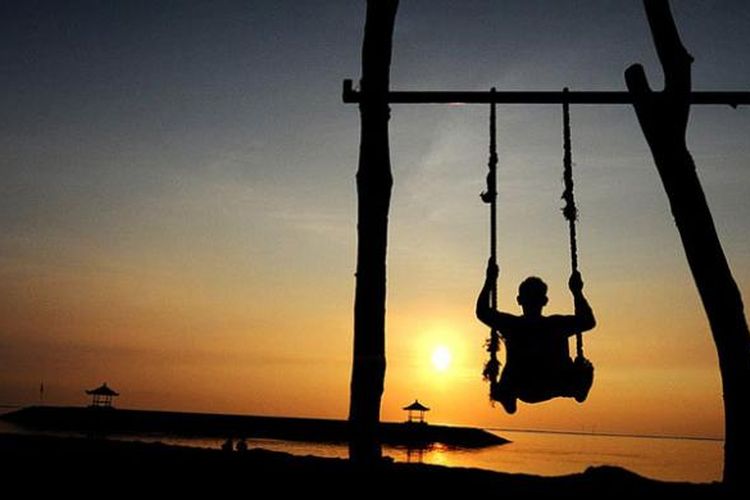 Cara lain menikmati kehangatan matahari terbit di pantai Sanur, Bali, Senin (20/2/2017). 