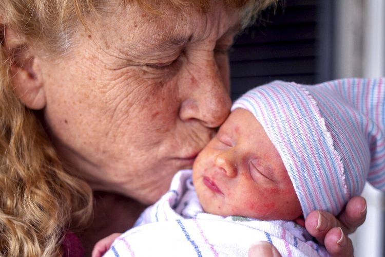 Barbara Higgins menggendong bayinya pada Rabu (24/3/2021) di Concord, New Hampshire, Amerika Serikat (AS). Higgins yang kehilangan putrinya yang berusia 13 tahun karena tumor otak pada 2016 telah melahirkan seorang putra pada usia 57. 