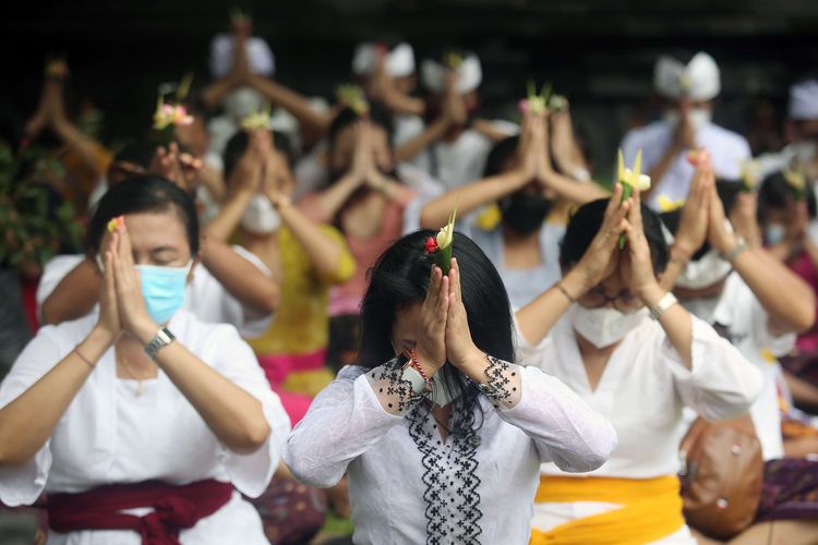 Umat Hindu melakukan persembahyangan yang menjadi bagian dari Upacara Tawur Agung terlihat mengenakan gelang Tridatu di tangan kanan.