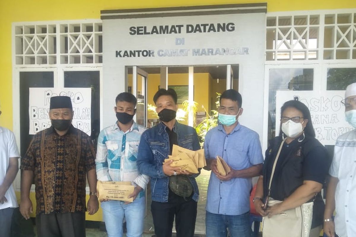 Kepala Dinas Sosial Tapanuli Selatan Nurdin Pane dan Pekerja Sosial (Peksos) Ahli Madya Direktorat Perlindungan Sosial Korban Bencana Sosial (PSKBS) Johanna Carolina menyerangkan santuan kepada ahli waris dari 12 korban tewas bencana tanah langsor di Kantor Camat Marancar, Tapanuli Selatan, Rabu (12/5/2021). 
