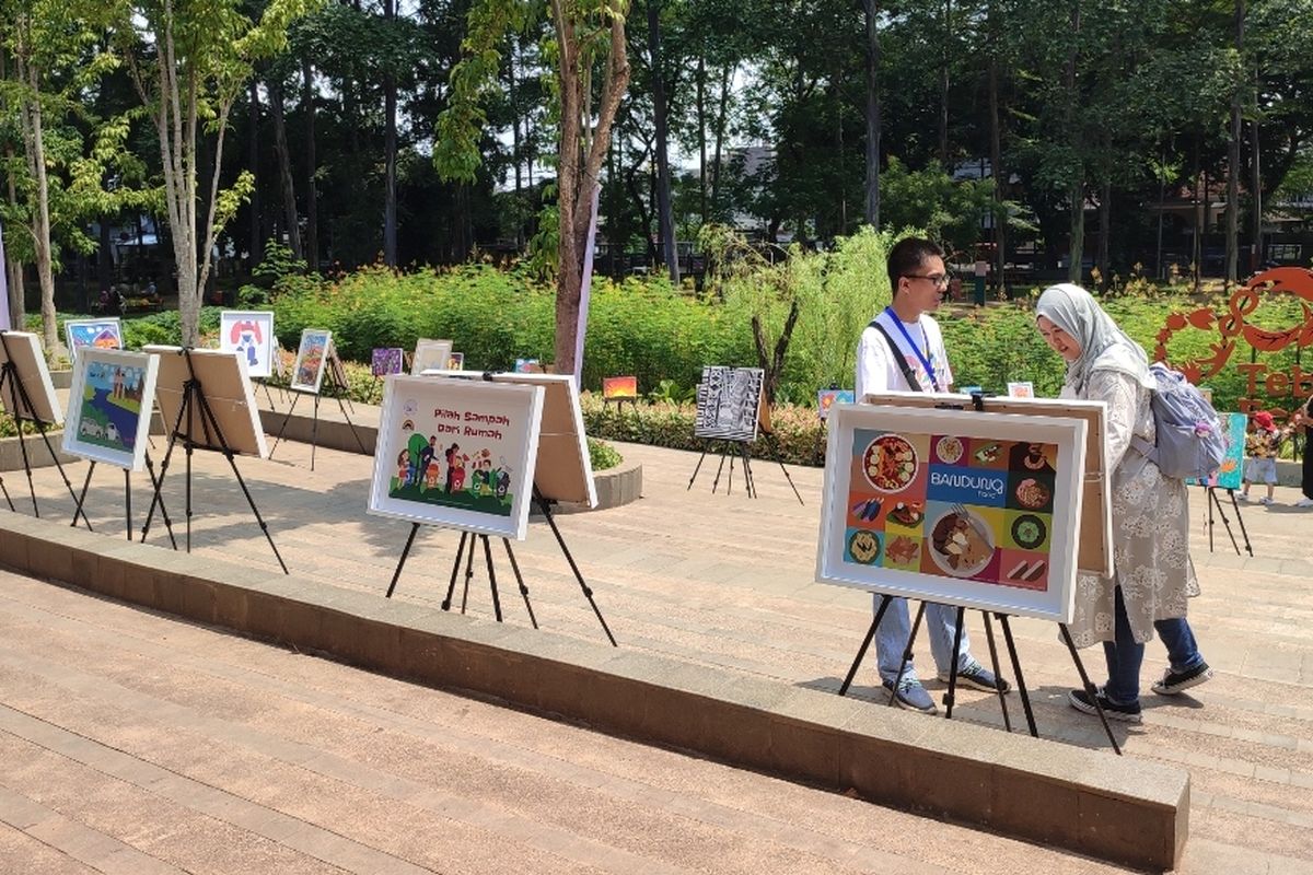 Sejumlah lukisan dan foto desain grafis berderet terpajang rapih di akses pintu masuk Tebet ECO Park, Jakarta Selatan. Karya seni yang menggunakan cat air itu menarik perhatian pengunjung yang datang ke Tebet Eco Park pada Sabtu (16/12/2023).