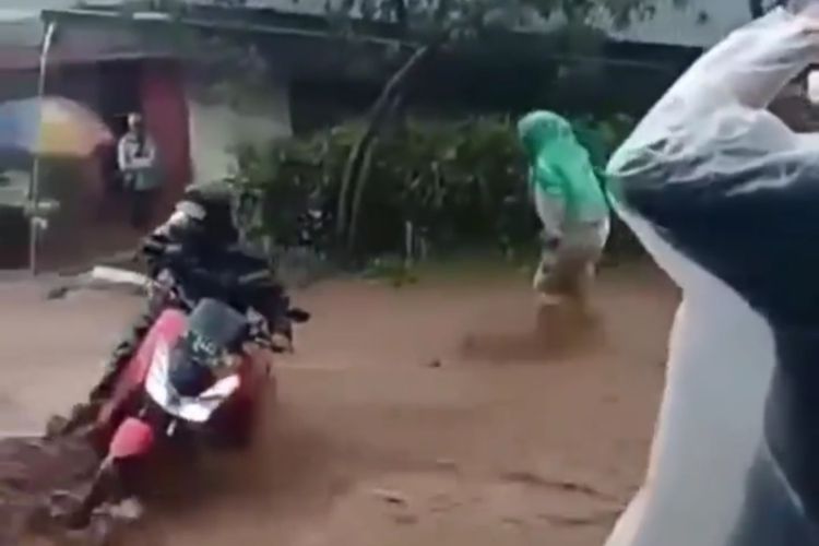 Pengendara sepeda motor nyaris terjatuh saat menerjang arus banjir yang melanda jalan provinsi di Desa Bakal, Kecamatan Batur, Kabupaten Banjarnegara, Jawa Tengah, Kamis (3/2/2022).