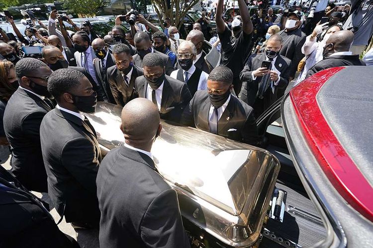 Pallbearer memindahkan peti mati George Floyd ke mobil jenazah setelah upacara pemakamannya di Gereja The Fountain of Praise di Houston, AS,  Selasa (9/6/2020). Ribuan pelawat baik di dalam tempat penghormatan terakhir hingga di jalanan menuju area pemakaman berbaris seiring peti berlapis emas yang membawa jasad Floyd dibawa menggunakan kereta kuda.